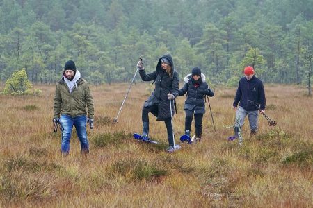 Räätsamatk rabamatk Tõlinõmme rabal. Matkajad väiksel lageraba lõigul räätsade ja keppidega